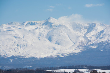 Fototapeta na wymiar 冬の火山の山頂と青空　十勝岳