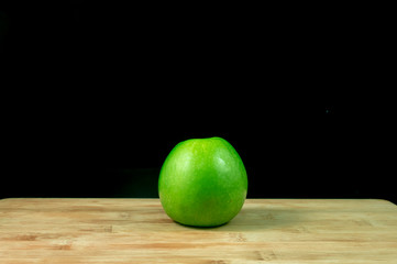Fresh organic green apple on wood