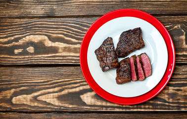 steak, roast beef on a plate on a wooden background