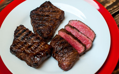 steak, roast beef on a plate on a wooden background