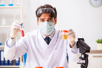 Young handsome chemist working in the lab