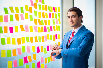 Young handsome employee with many conflicting priorities   