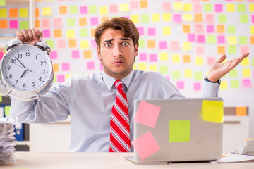 Young handsome man in conflicting priorities concept