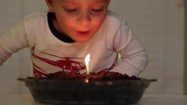 Boy Blowing Out Candle
