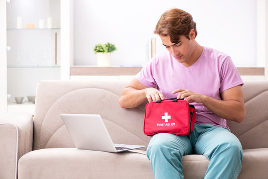 Sick man at home with first aid kit
