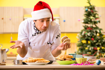 Young chef husband working in kitchen at Christmas eve 