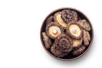 Dried shiitake mushrooms in a wooden bowl on white background, Top view.