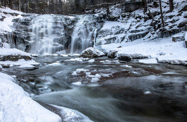 Waterfall in snowy forest. Winter Mumlava Waterfall in Harrachov, Krkonose mountains, Czech Republic