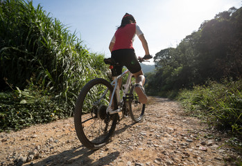 Fototapeta premium Woman ccyclist riding a bike on a nature trail in the mountains.people living a healthy lifestyle
