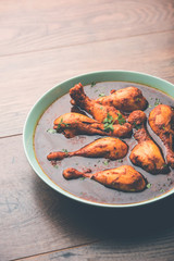 Chicken leg / drumstick curry or Murg Tangri/tangdi masala. Served in a bowl over moody background. Selective focus