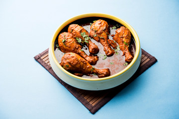 Chicken leg / drumstick curry or Murg Tangri/tangdi masala. Served in a bowl over moody background. Selective focus