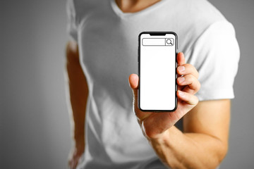 Search bar on the phone screen. A man holding a black smartphone with a white blank screen. Smartphone with large screen. Close up. Isolated background
