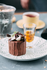 Crème brûlée with chocolate dessert with flowers. Foodstyling with tea on wooden background.