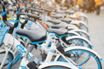 Bicycle rental service on city road parking with sunlight, public transportation concept.