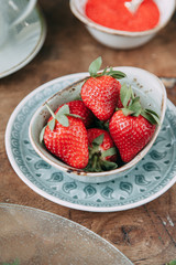 Pavlova dessert with berries in a beautiful composition. Foodstyling on a wooden background with coffee and strawberries.