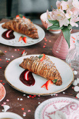 Croissants on a chic table with coffee and desserts. Food styling and layout with jam and berries.