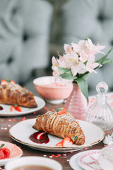 Croissants on a chic table with coffee and desserts. Food styling and layout with jam and berries.