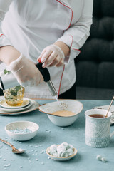 Burning creme brulee with coffee. Foodstyling of desserts and layout on a wooden background