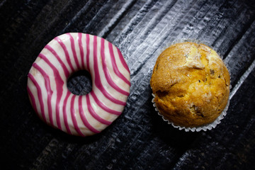 Donut and cupcake on black background