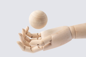 wooden hand with wood ball isolated on white