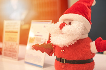 Happy new year and Merry Christmas concept. Santa Claus doll ornament at front desk reception with receptionist in hotel during greeting seasons holidays in winter.