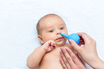 mother cleaning the nose of a newborn with a clyster