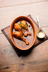 Fototapeta na wymiar Chicken leg / drumstick curry or Murg Tangri/tangdi masala. Served in a bowl over moody background. Selective focus