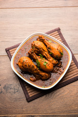 Chicken leg / drumstick curry or Murg Tangri/tangdi masala. Served in a bowl over moody background. Selective focus