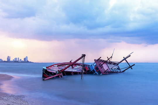 Shipwreck or wrecked boat on beach in the sunset. Beautiful Landscape. Night Pattaya Background. Thailand.