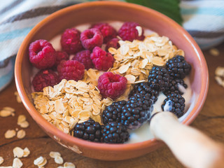 Smoothie yogurt bowl with oats and berries on wooden rustic board. Healthy eating breakfast