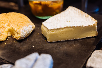 Brie cheese on black stone plate.