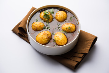 Fried egg curry or anda masala served in a bowl. selective focus