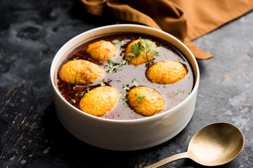 Fried egg curry or anda masala served in a bowl. selective focus