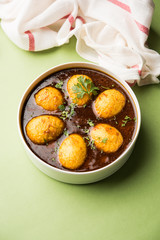 Fried egg curry or anda masala served in a bowl. selective focus