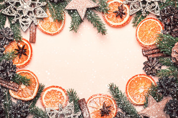 Christmas natural frame of Dry Oranges Slices, fir cones and branches. Vintage toning and snow