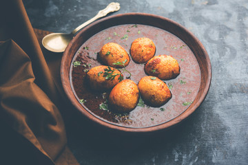 Fried egg curry or anda masala served in a bowl. selective focus