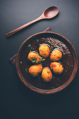 Fried egg curry or anda masala served in a bowl. selective focus