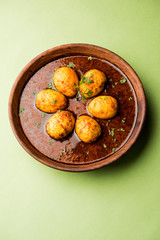 Fried egg curry or anda masala served in a bowl. selective focus