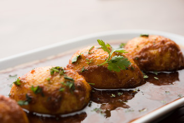 Fried egg curry or anda masala served in a bowl. selective focus
