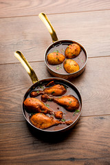 anda/egg curry with tangri/tangdi chicken masala. served in a serving pan. selective focus