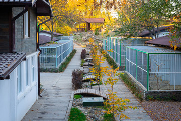Bird cages in the outdoor zoo with benches