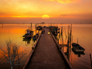 The beautiful landscape of Bangsaen(Thailand) sea port with fishery boat on golden light sunset.