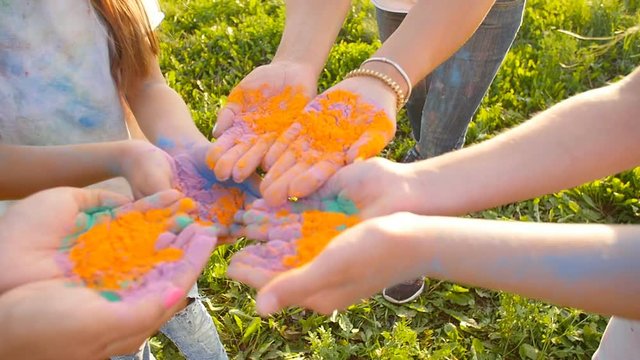 Happy mothers with children having fun with colorful powder at holi festival of colors