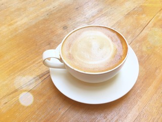 coffee cup Cappuccino on wood table with orange light