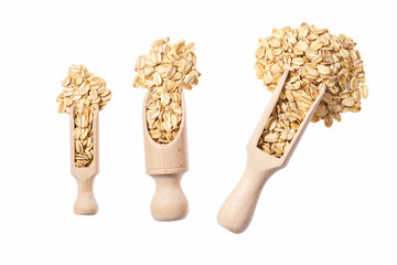 Uncooked oatmeal in  wooden  spoon isolated on white top view