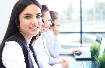 Businesswoman wearing microphone headset using computer in the office - operator, call center.