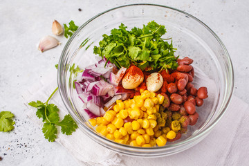 Ingredients for vegan meatballs from beans and corn in glass bowl.