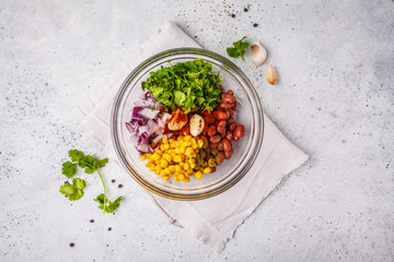 Ingredients for vegan meatballs from beans and corn in glass bowl.