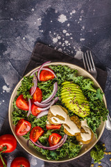 Vegan lentil meatballs salad with kale, avocado, tomato and tahini dressing.