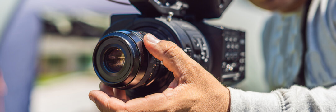a professional cameraman prepares a camera and a tripod before shooting BANNER, long format